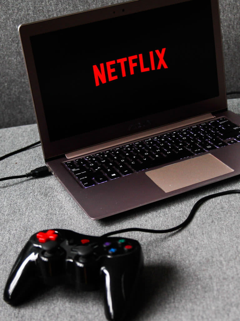 Netflix logo displayed on a laptop screen and a gamepad are seen in this illustration photo taken in Krakow, Poland on August 5, 2021. (Photo by Jakub Porzycki/NurPhoto via Getty Images)