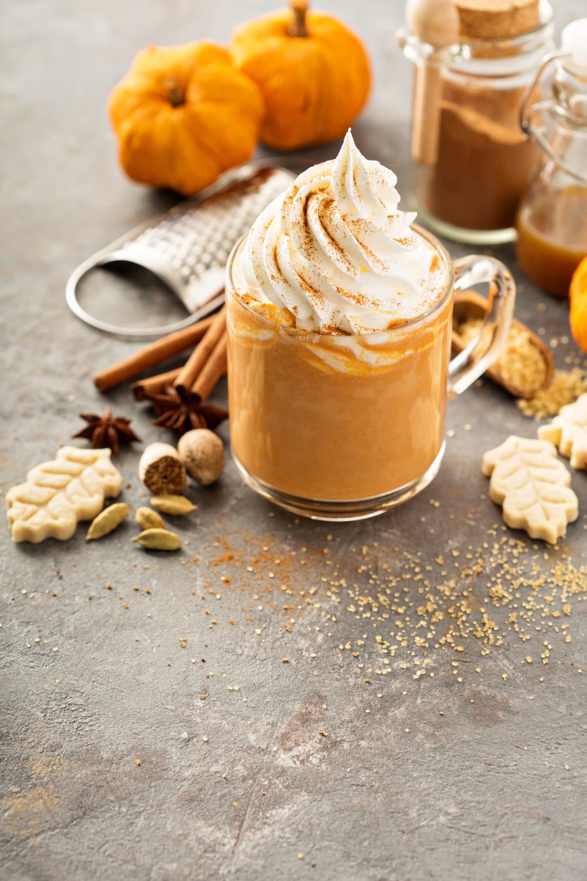 Glass of pumpkin layered spice latte with pumpkin puree. milk foam. sweet glazed sticks and cinnamon standing on white marble table. Copy space. (Photo by: Natasha Breen/REDA&CO/Universal Images Group via Getty Images)