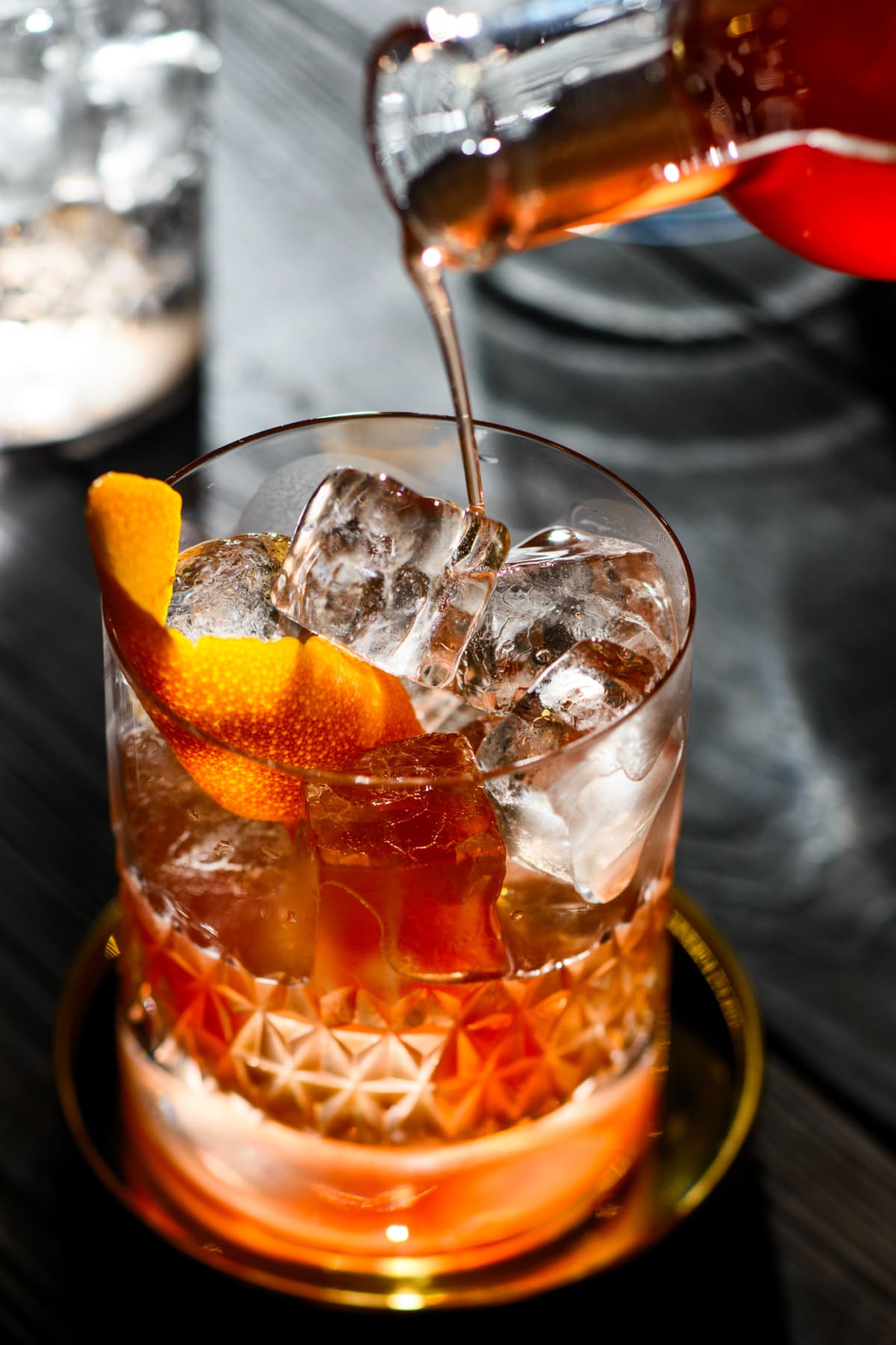Close up of a whiskey cocktail with orange peel