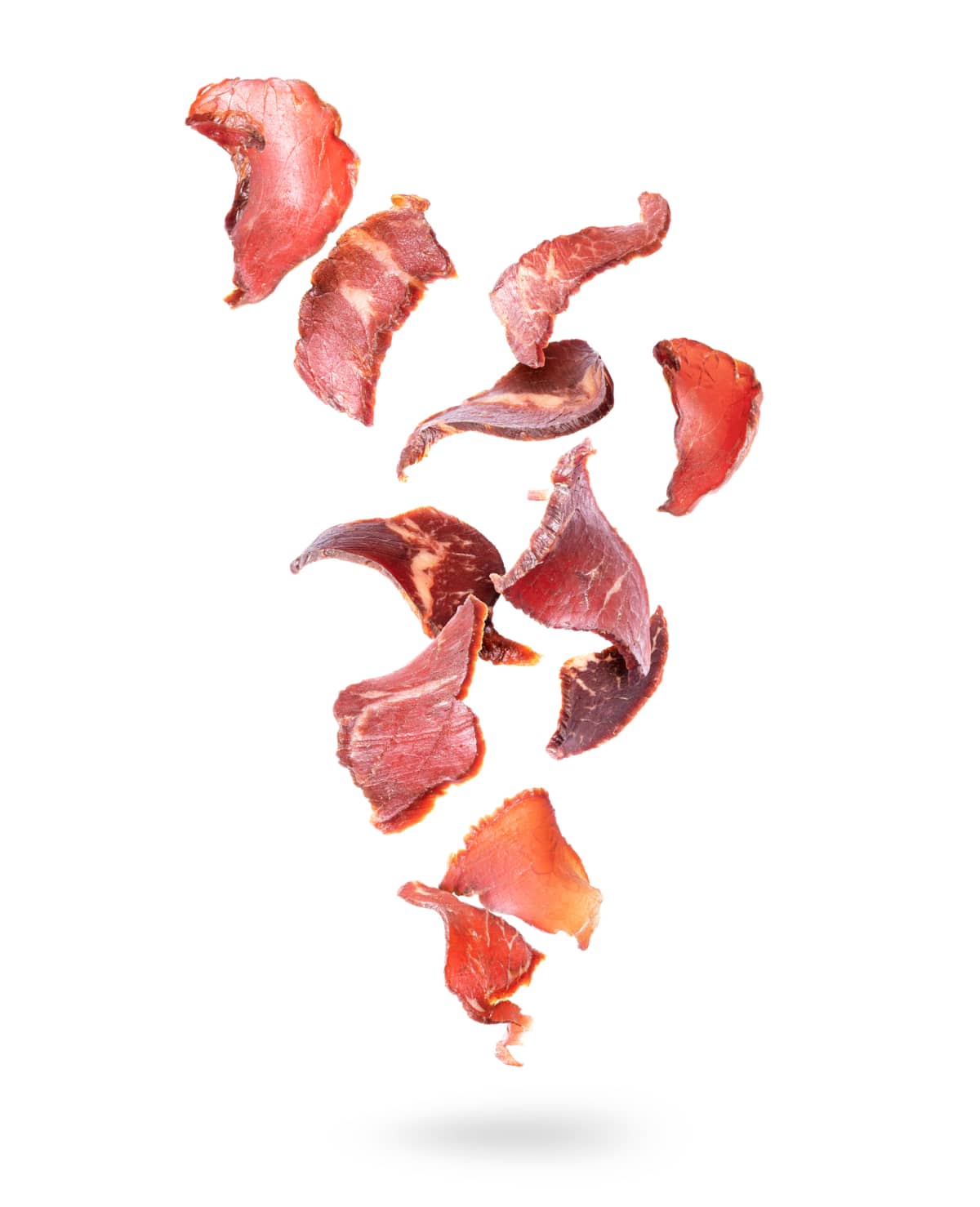 Beef jerky pieces in the air on a white background