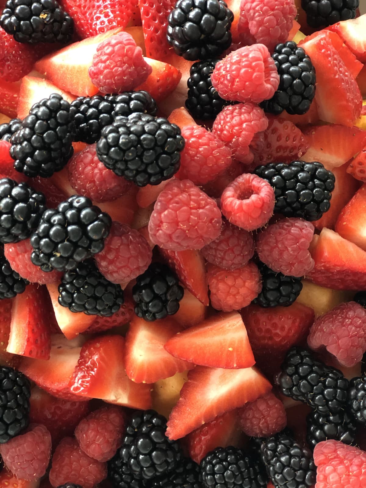 A mixture of fresh strawberries, raspberries and blackberries as part of a springtime meal.