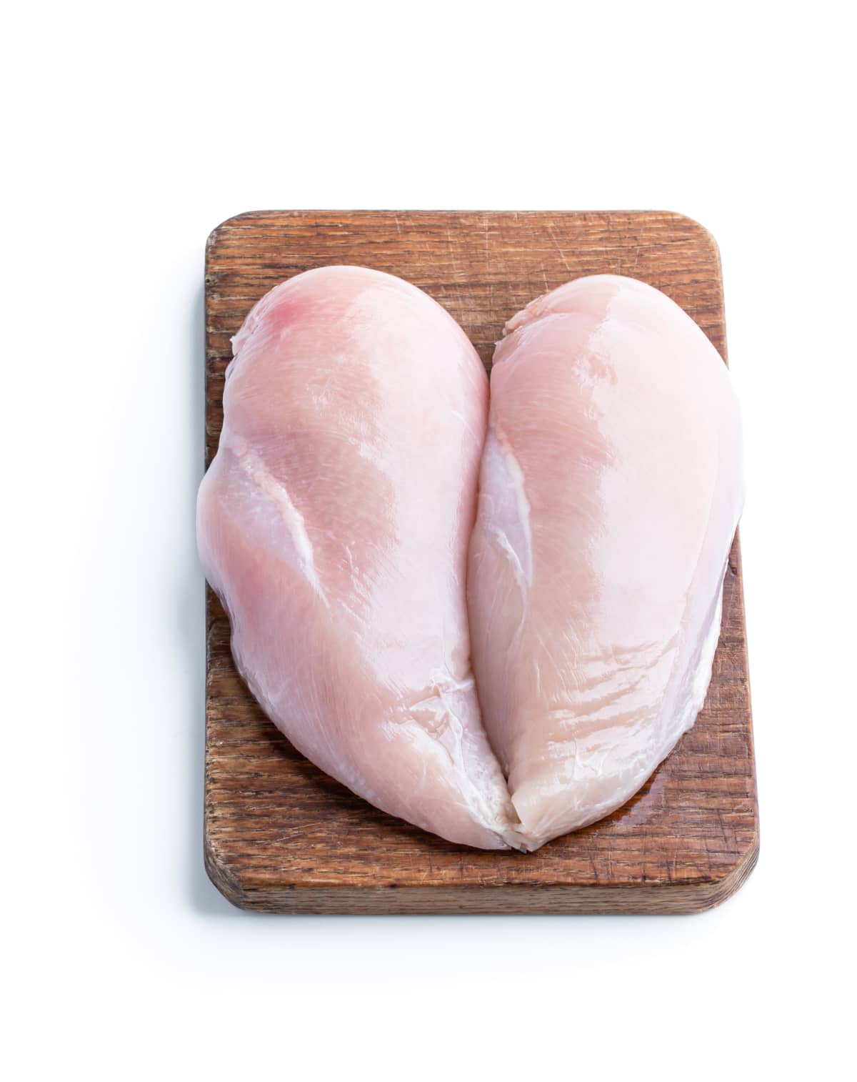 Two raw chicken breasts on a cutting board