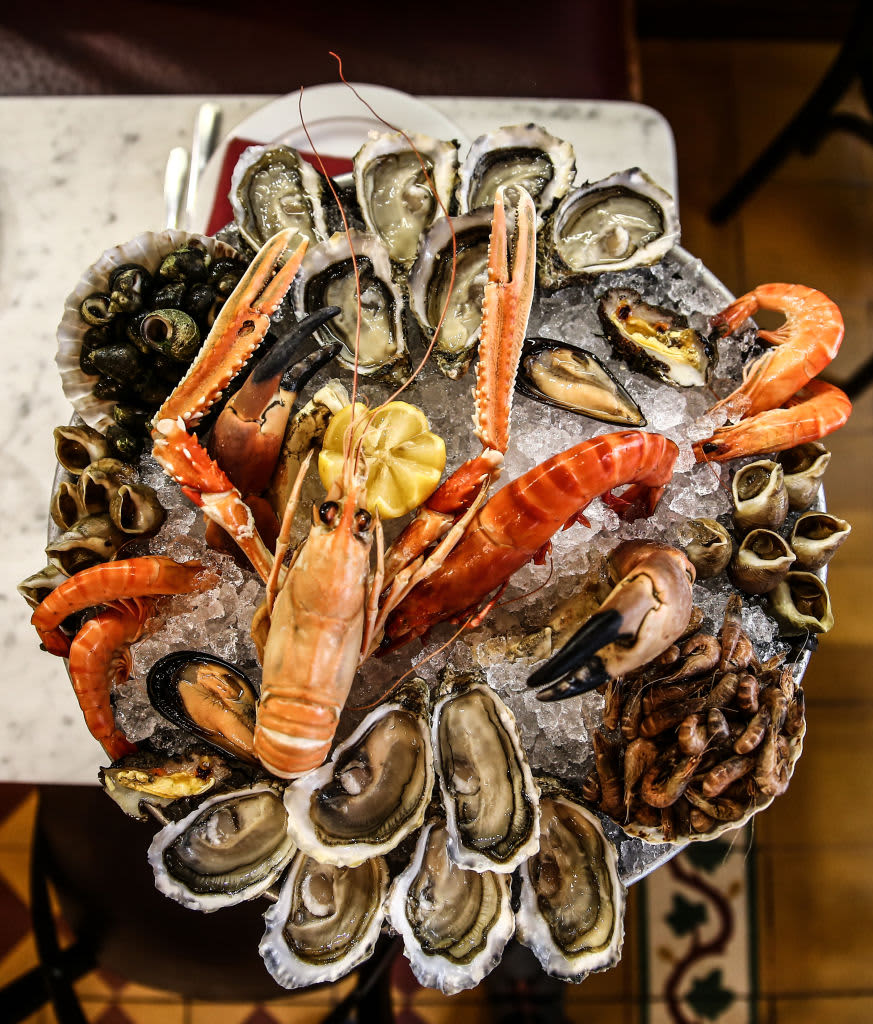 A platter of seafood on ice including lobster, crab, and oysters