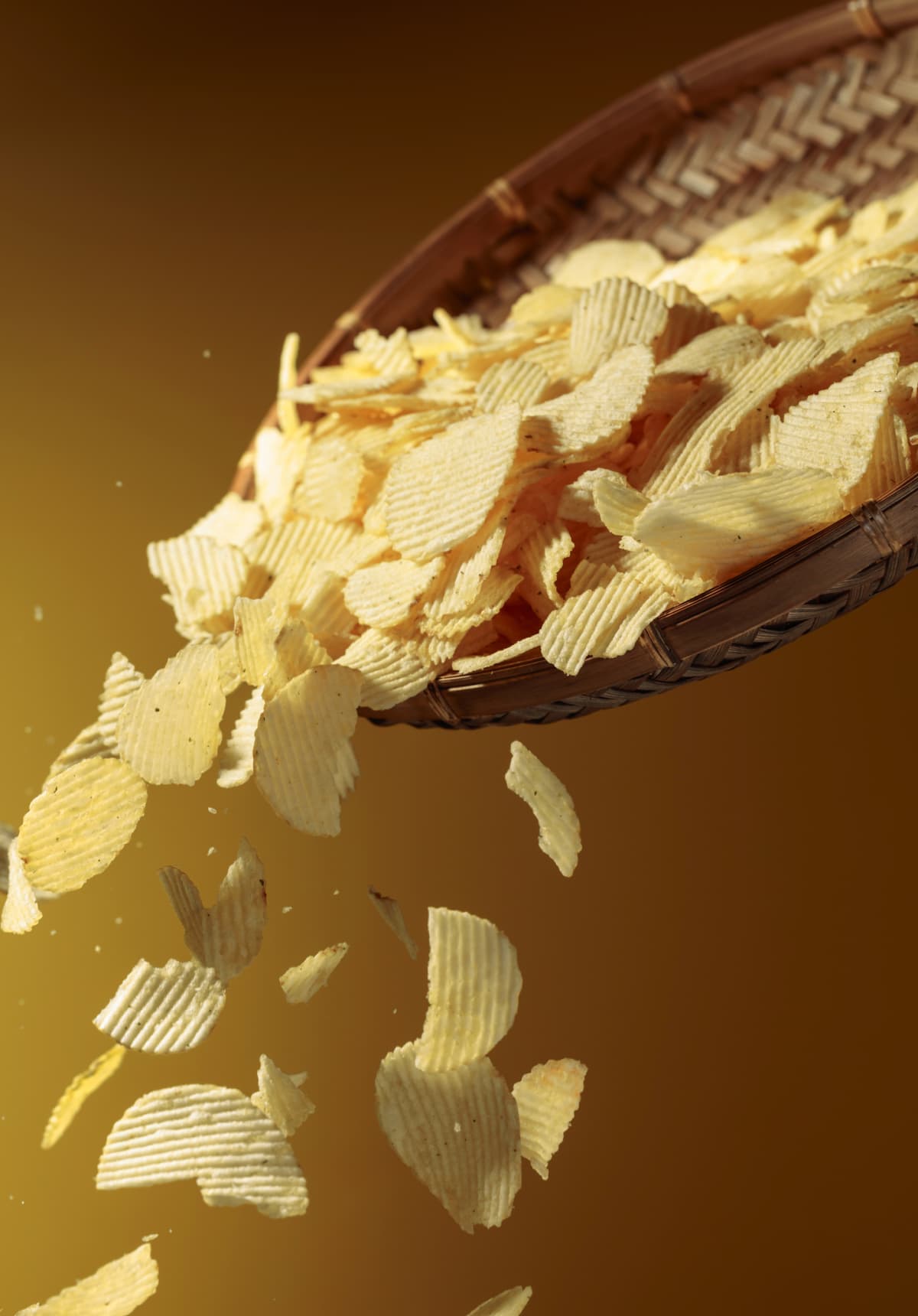 Falling potato chips on a yellow background. Copy space.