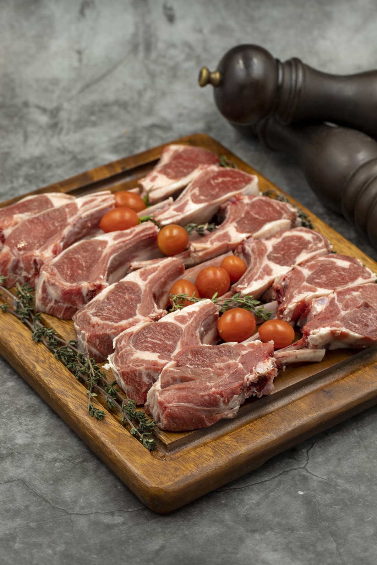 Lamb chops on dark background. Raw lamb chops on wood serving board