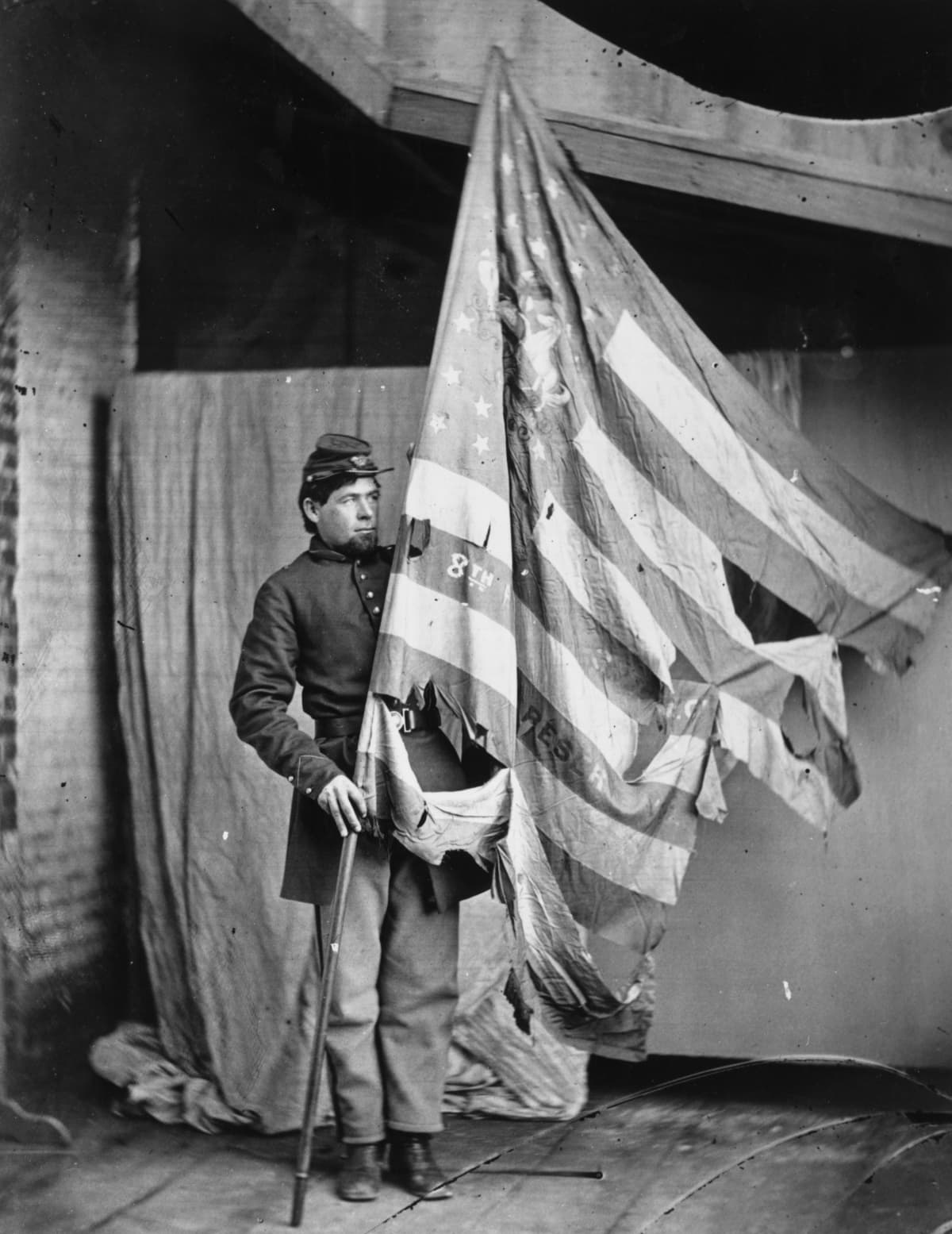 A soldier holding up the torn flag of the 8th Pennsylvania Reserve Colour Guard during the American Civil War.   (Photo by MPI/Getty Images)