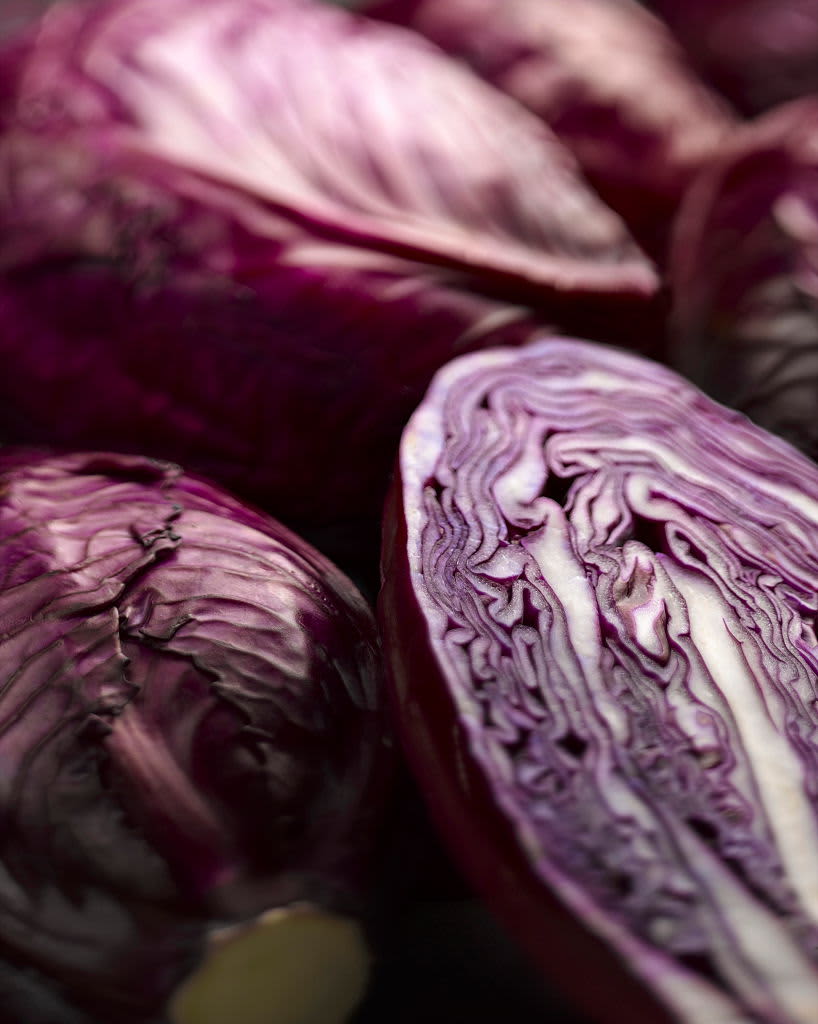 Cabbage, Red cabbage, Brassica oleracea capitata. A cut half among whole ones. Moody lighting. (Photo by FlowerPhotos/Universal Images Group via Getty Images)