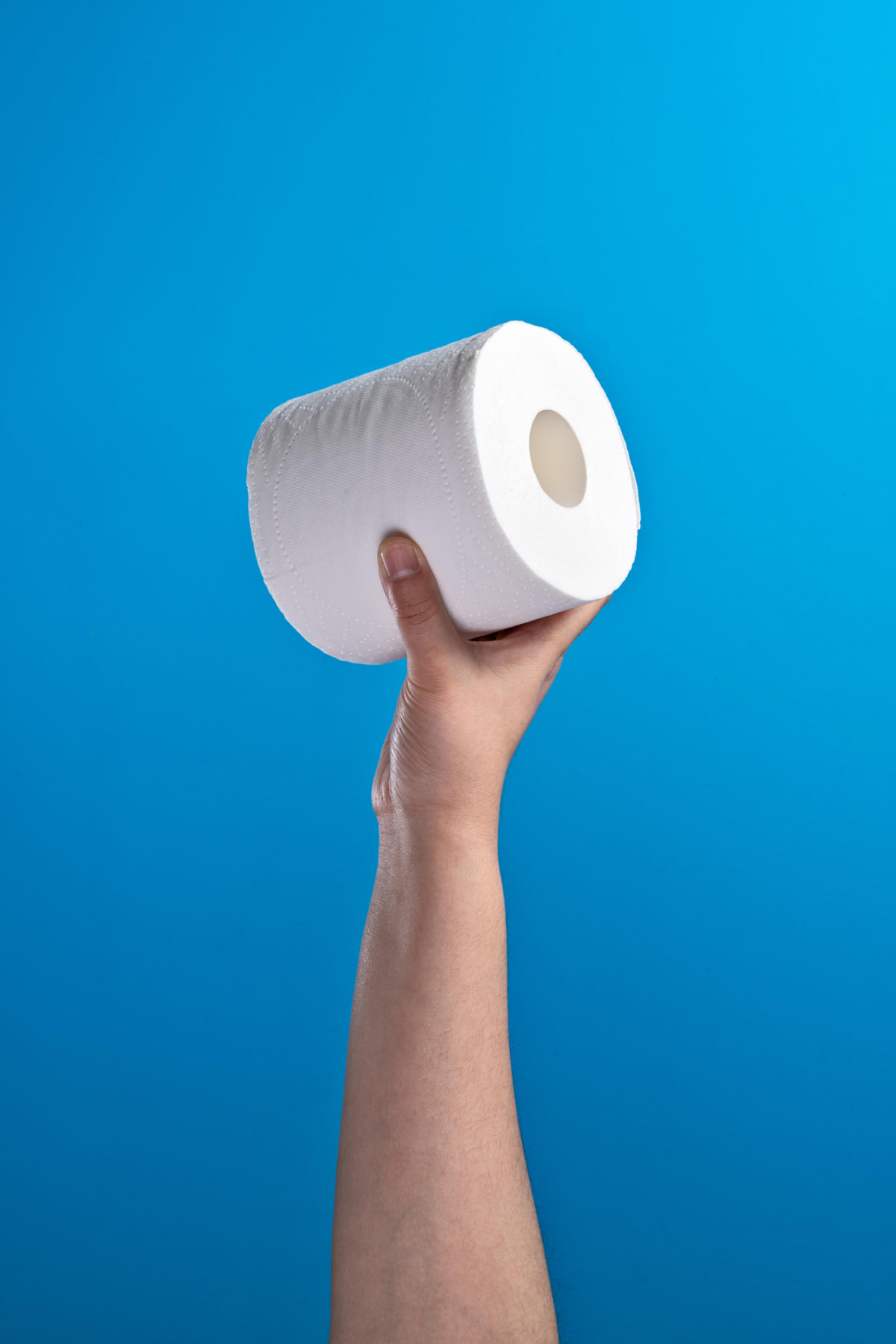 Hand holding toilet paper roll aloft