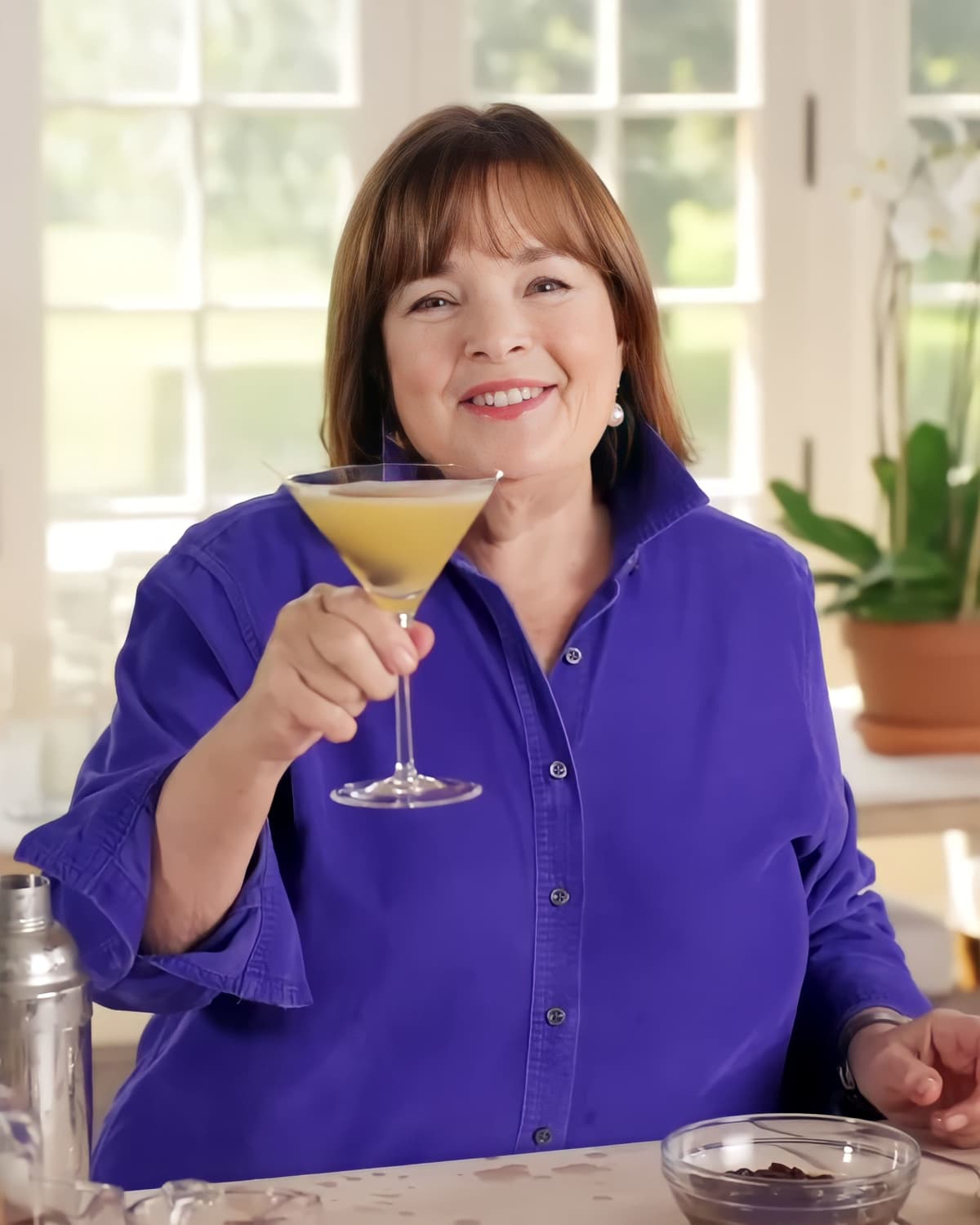 Ina Garten smiling and holding a glass of cocktail
