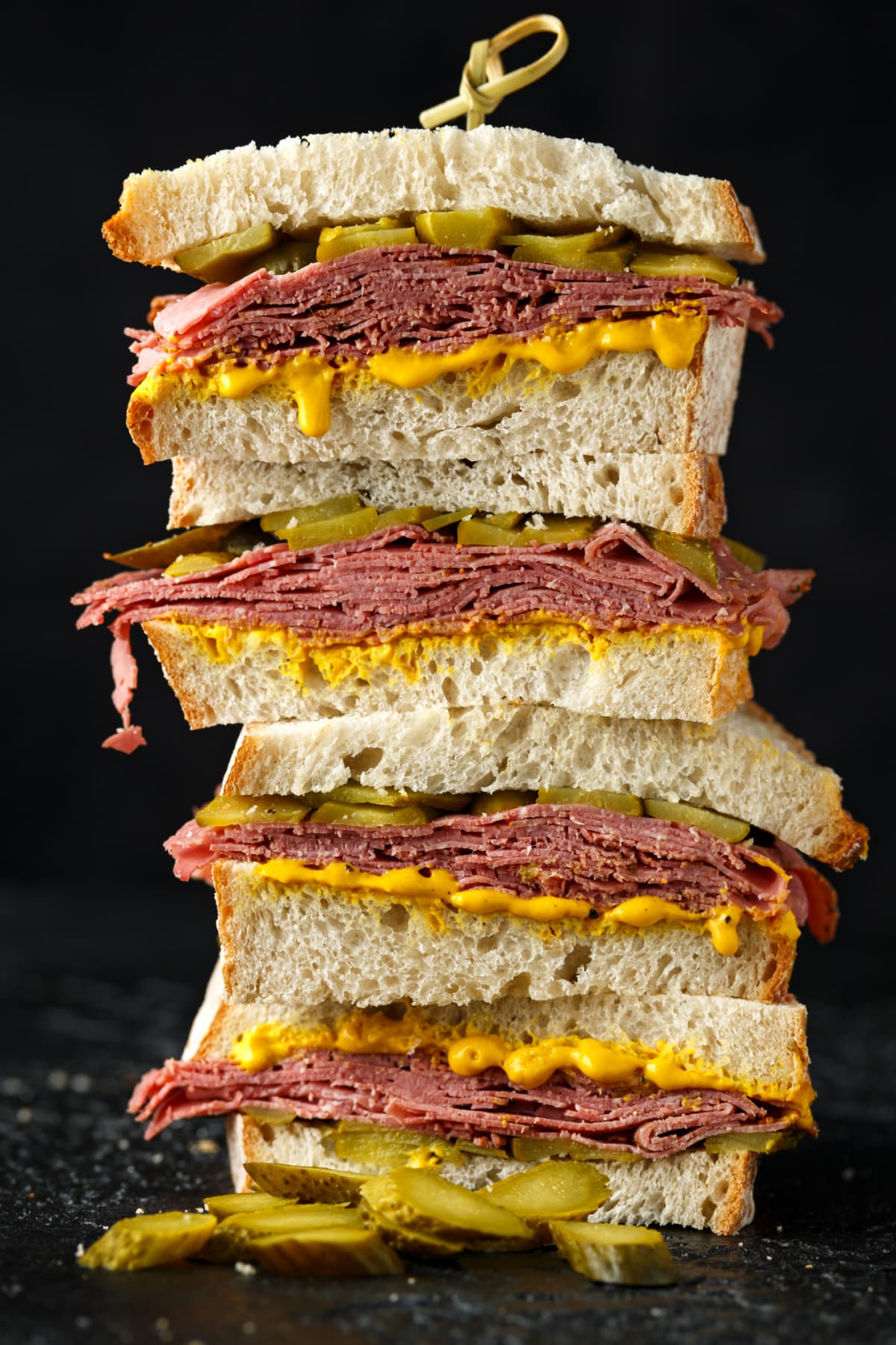 Stacked New York Pastrami sandwiches on black background