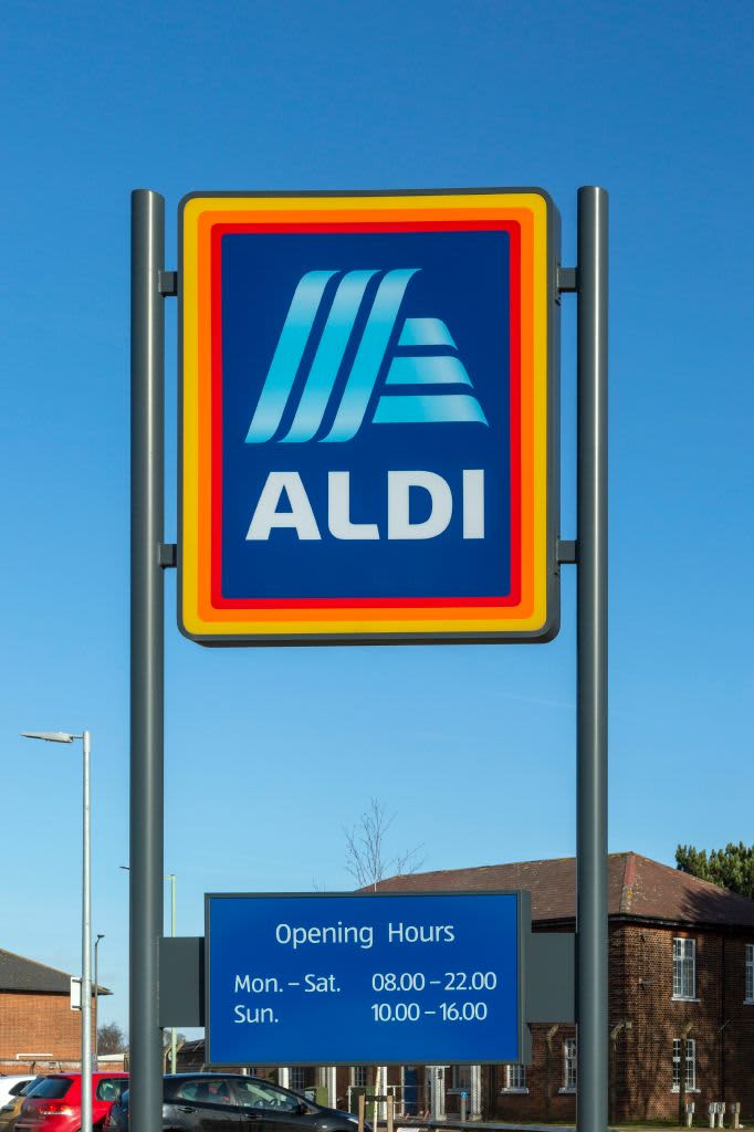 Aldi shop sign with opening hours against blue sky, Martlesham Heath, Suffolk, England, UK. (Photo by: Geography Photos/UCG/Universal Images Group via Getty Images)