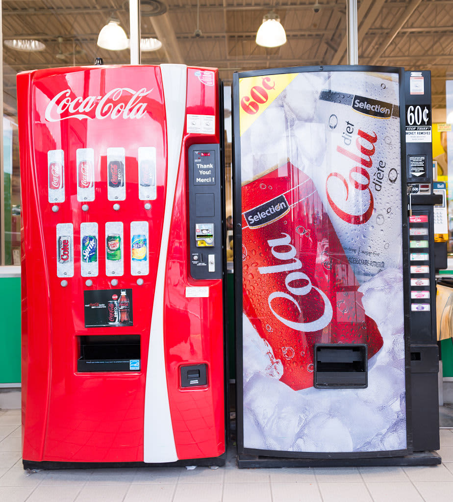 TORONTO, ONTARIO, CANADA - 2015/03/21: Coca Cola and a generic brand name machines in grocery store. Despite unhealthy reviews carbonated drinks sell a lot and many companies want a cut in profits. (Photo by Roberto Machado Noa/LightRocket via Getty Images)