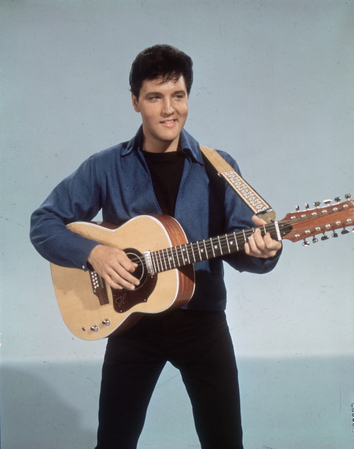 circa 1955:  American rock 'n roll singer Elvis Presley (1935 - 1977) with a twelve string guitar.  (Photo by Hulton Archive/Getty Images)