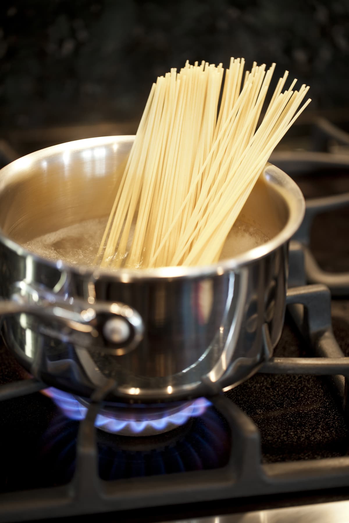Spaghetti being cooked in a pot of boiling water and Bolognese Sauce