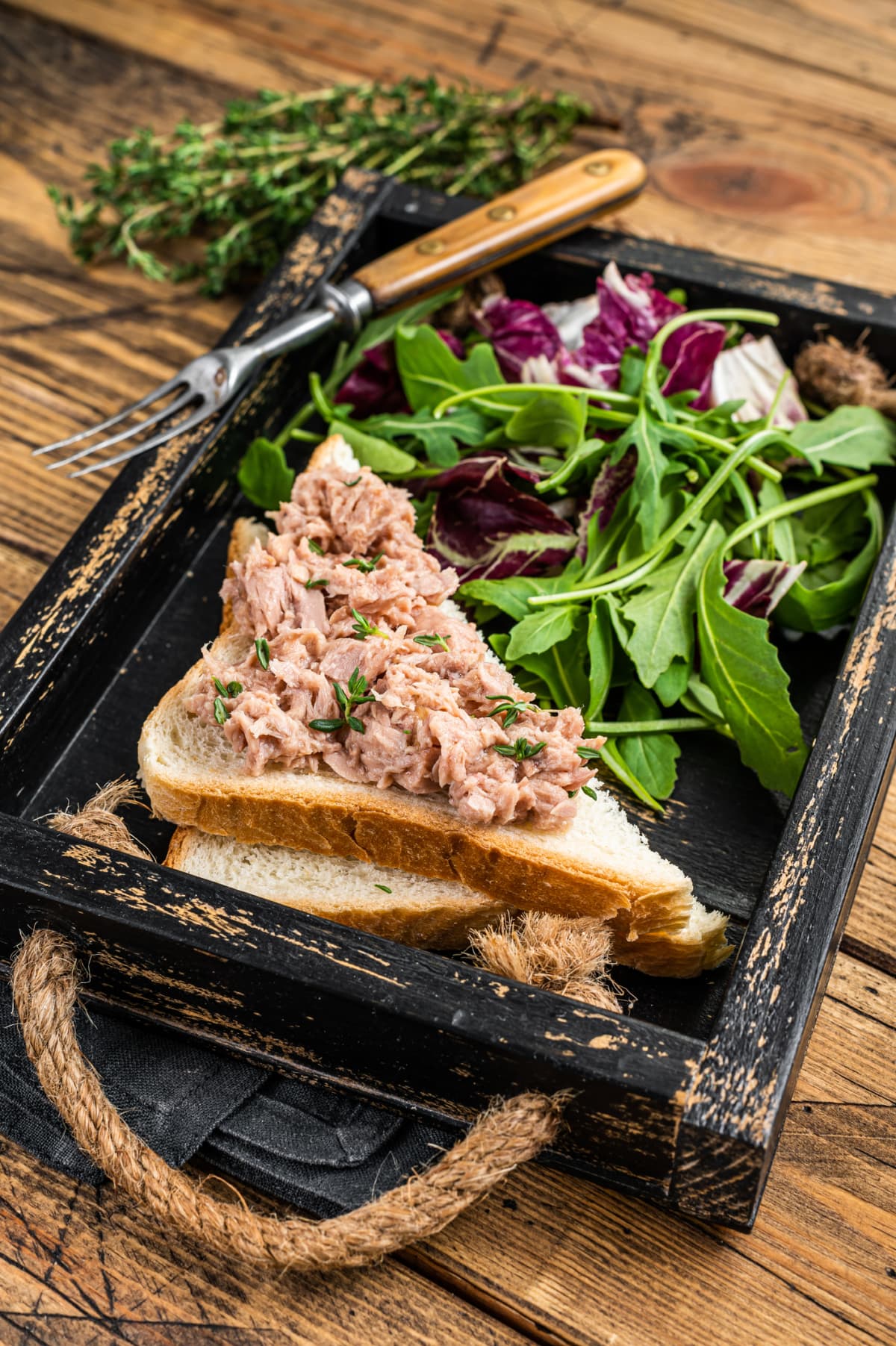 Tuna Salad Sandwich with Cheese, lettuce and arugula. Wooden background. Top view.