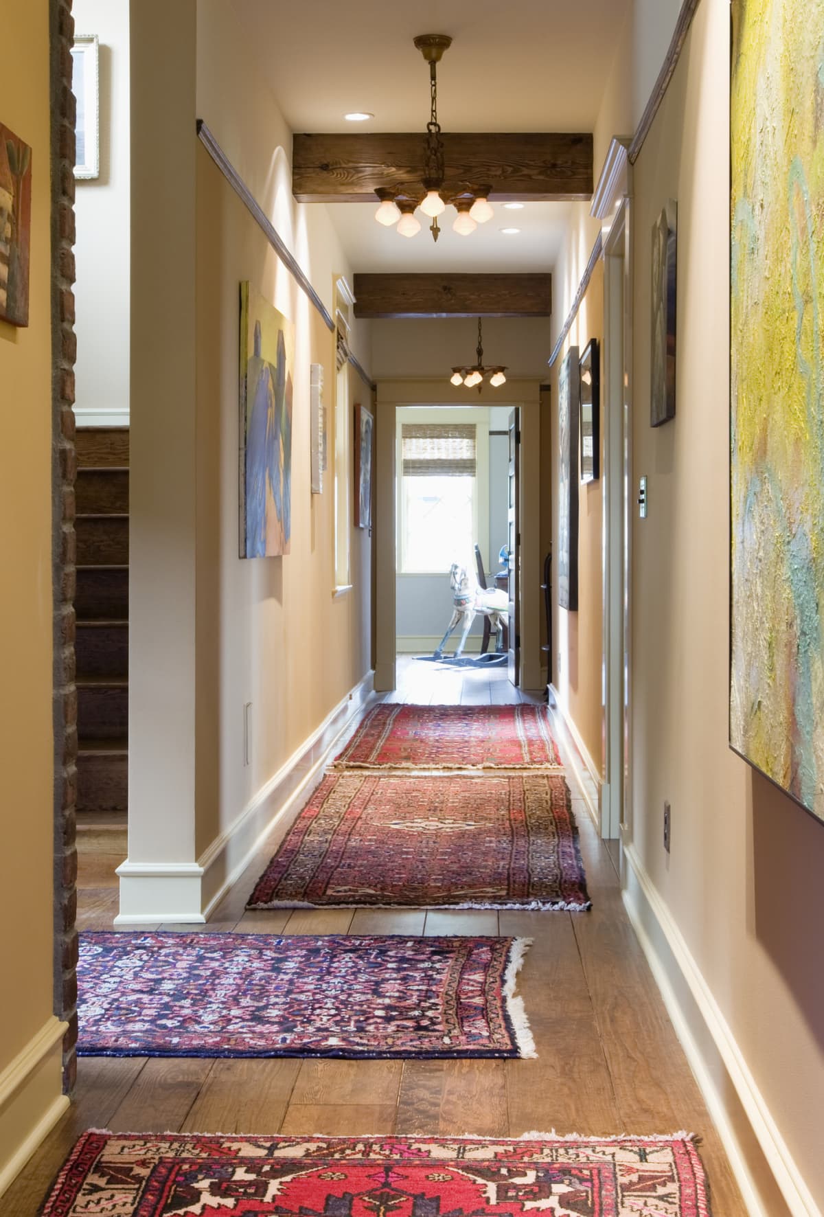 Hallway with artwork and rugs