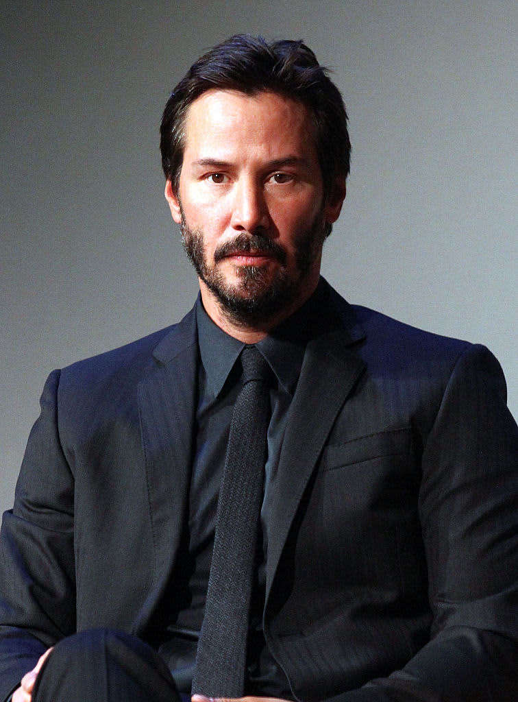 Actor Keanu Reeves in a dark suit