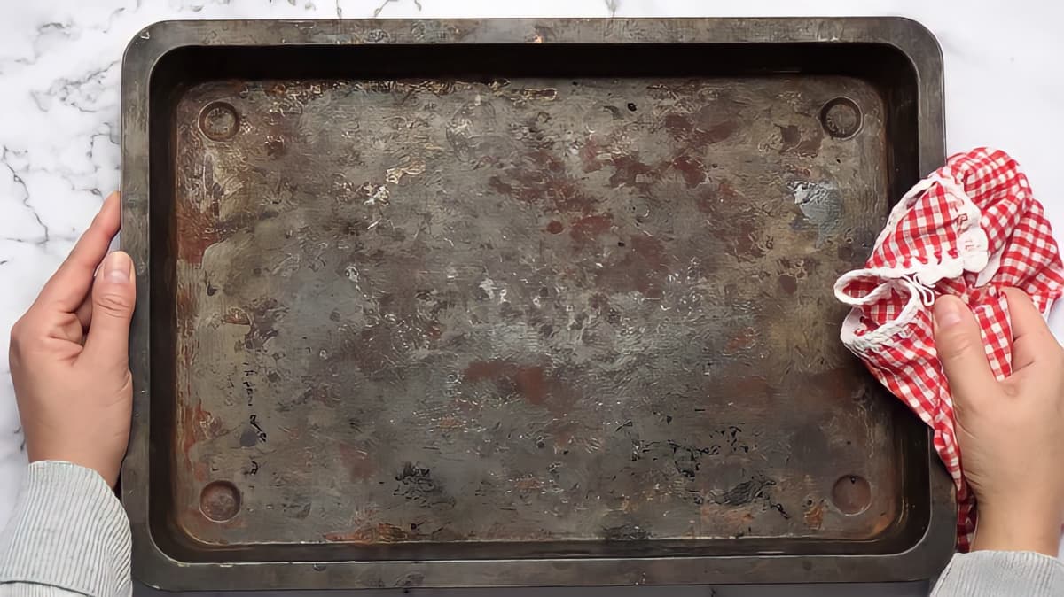 Person holding dirty baking tray