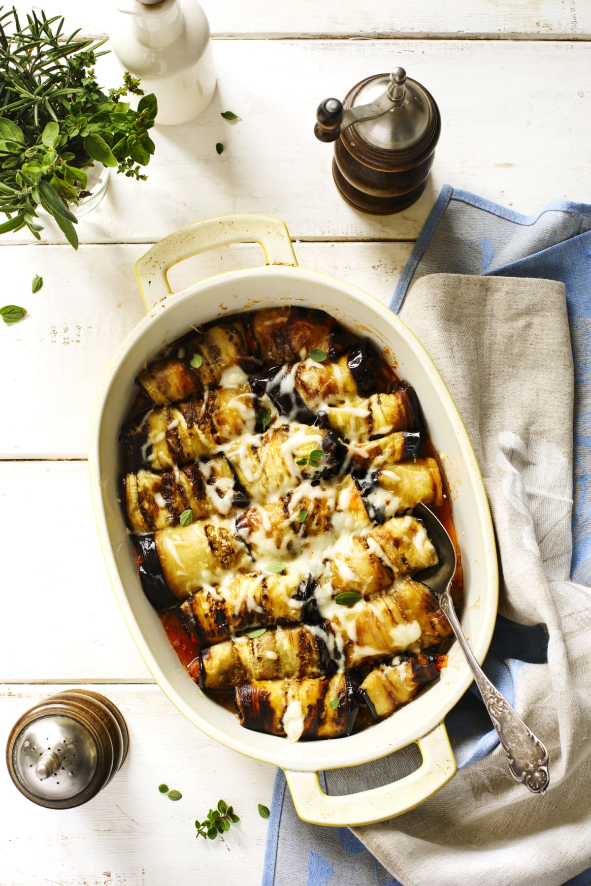 Casserole dish of baked eggplant rolls with cheese on top