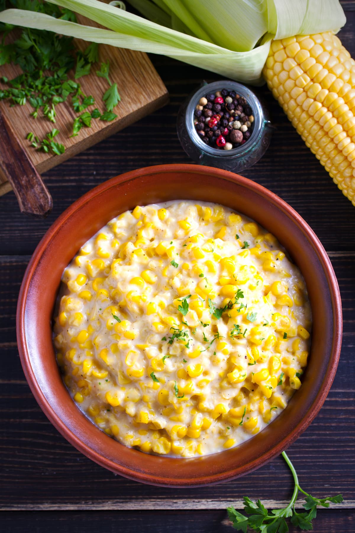 Sweet and creamy corn in bowl. Corn dish. overhead, vertical