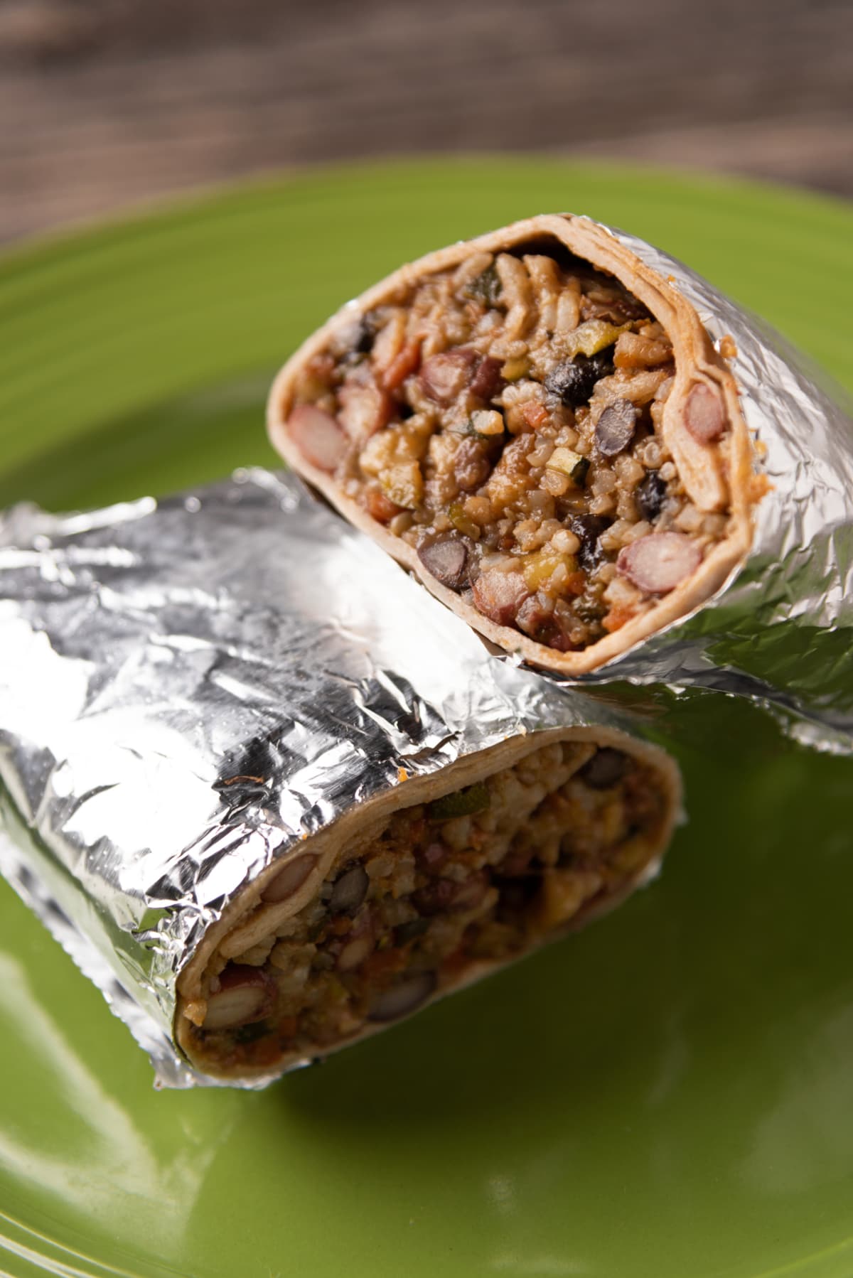 Mexican burrito with side salsa wrapped in foil.