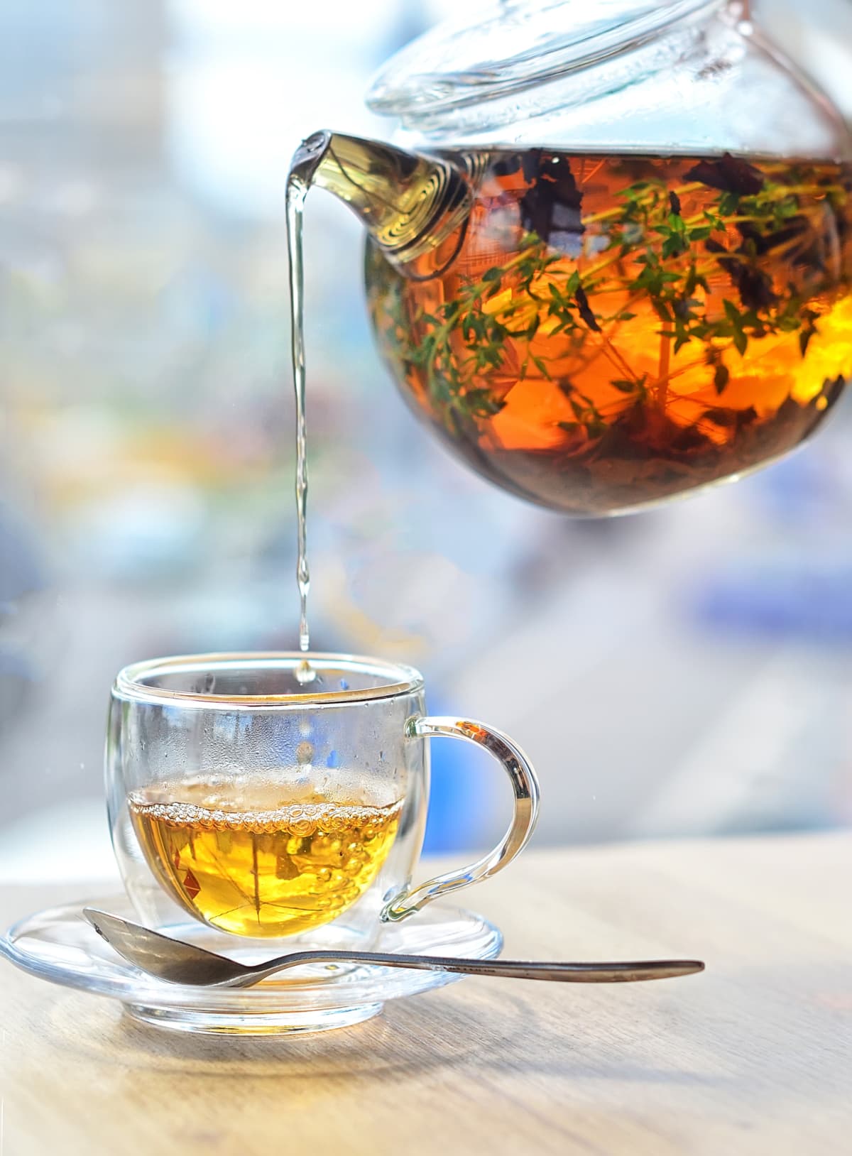 Tea poured from glass pot to glass cup
