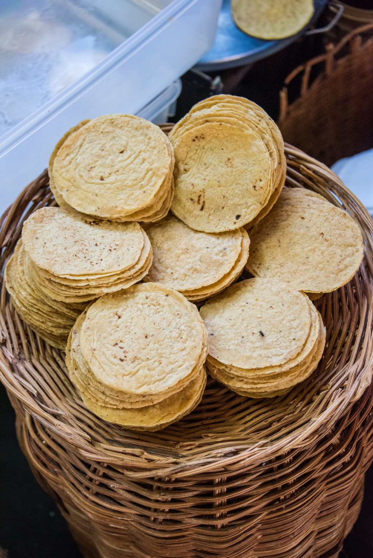 Corn tortillas in piles in a wicker basket