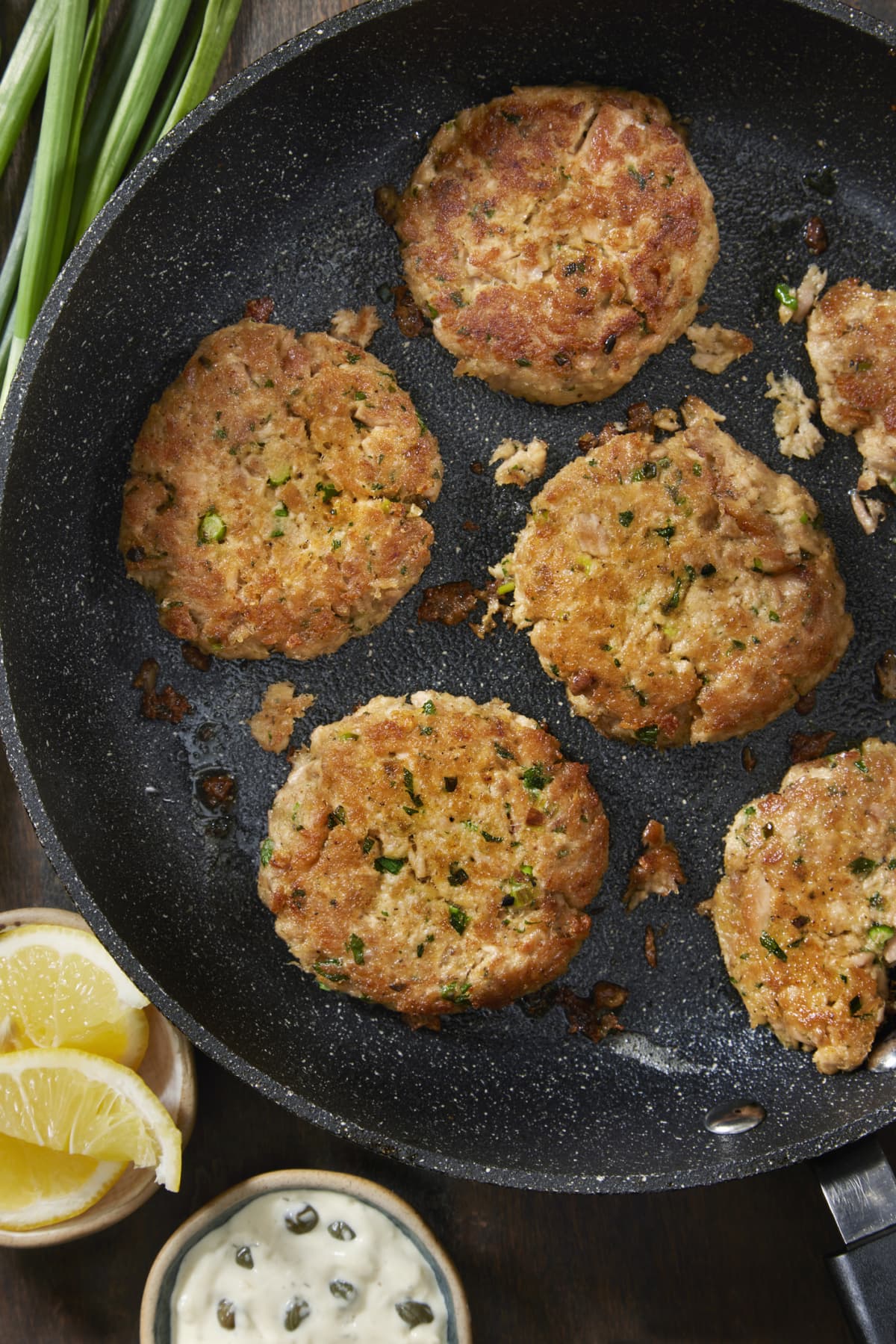 Homemade fish burger patties cooking in a pan
