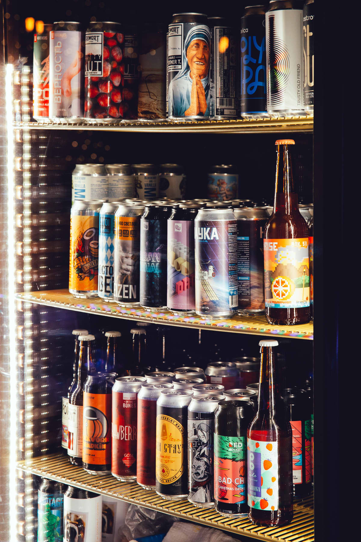 Cans of beer in a backlit fridge