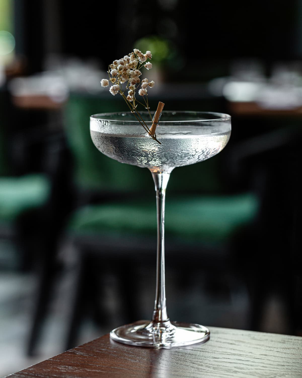 A cocktail in a martini glass with a flower garnish