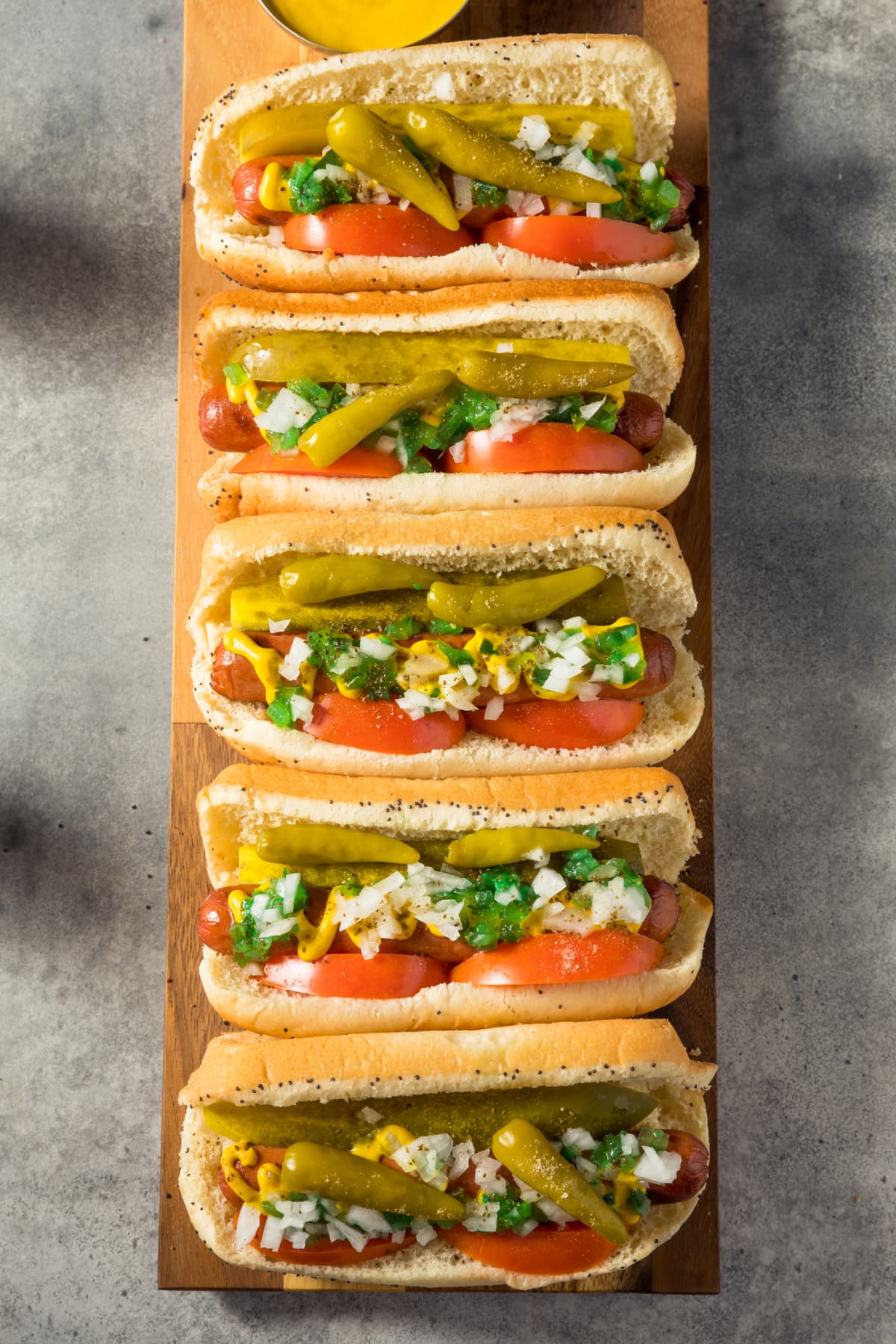 "A Classic Chicago Dog with Fries - The Chicago Dog has a Steamed Poppyseed Bun, Fresh Tomatoes, Diced Onions, Neon Green Relish, Peppers, Pickle, Yellow Mustard and a Dash of Celery Salt- Photographed on Hasselblad H3D2-39mb Camera"