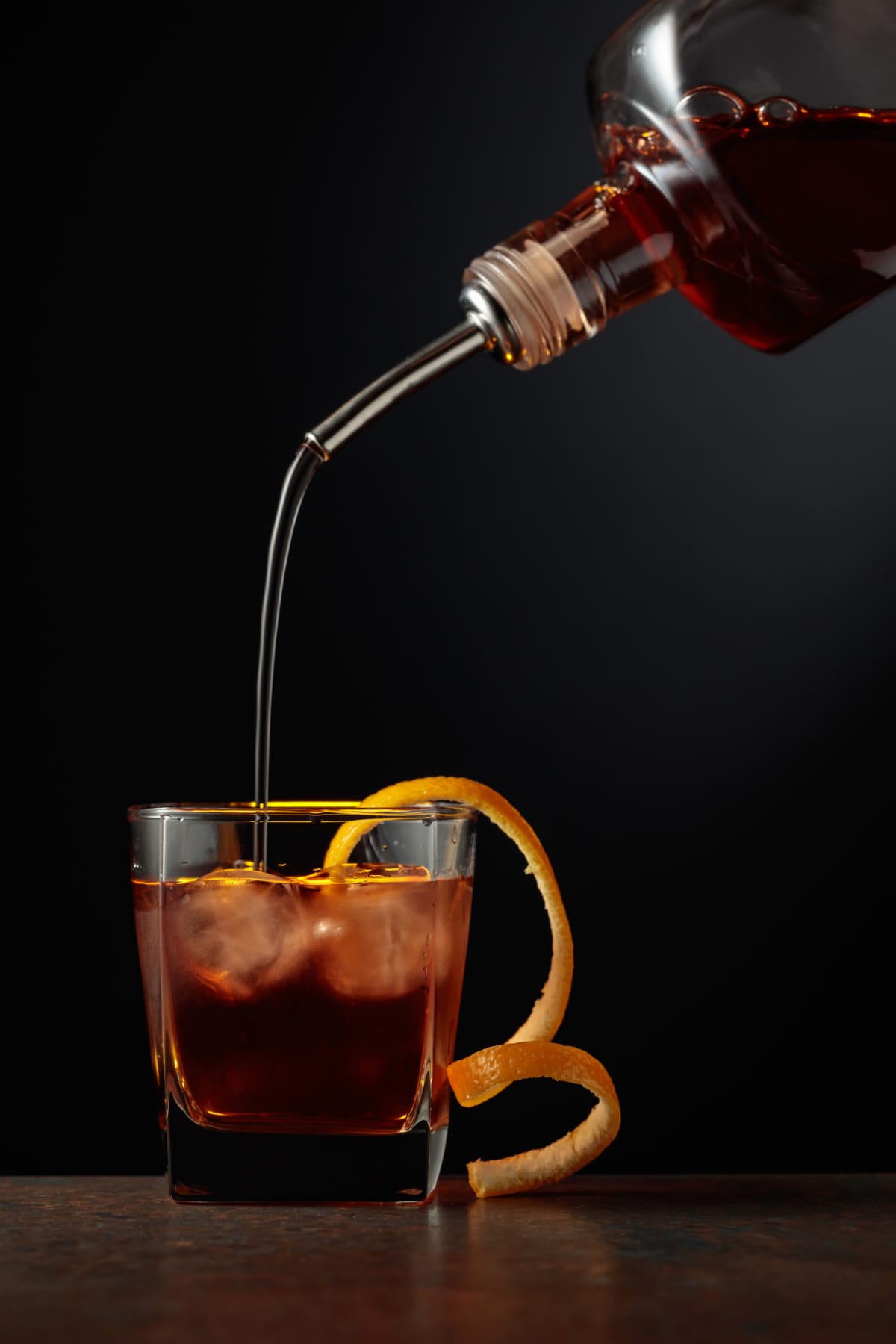 Pouring orange liqueur into cocktail