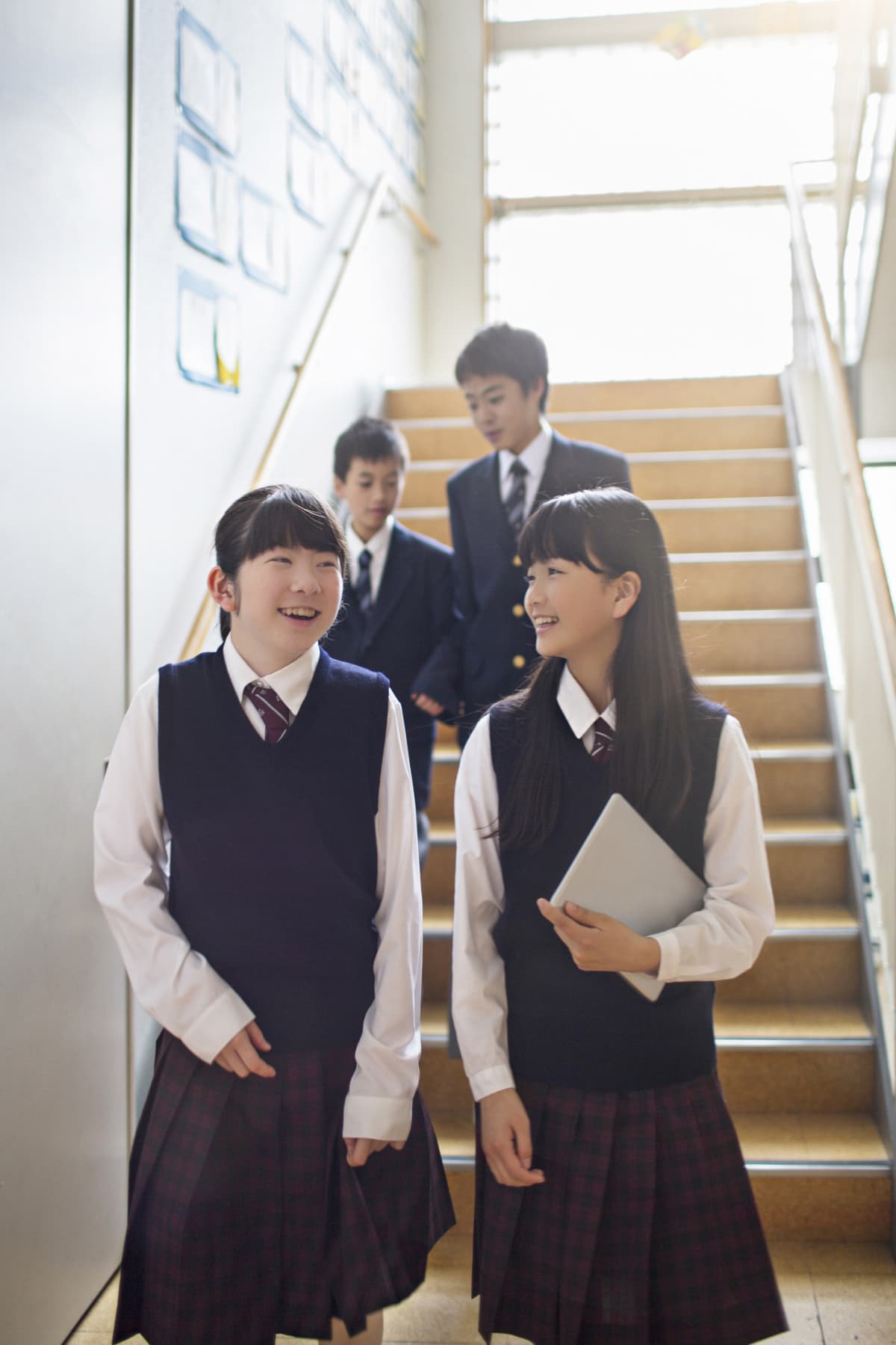 Japanese students walking in the school staircase.