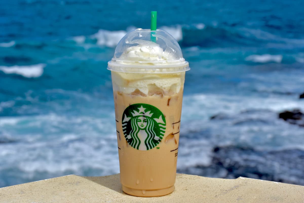Starbucks iced drink with whipped cream in front of the ocean