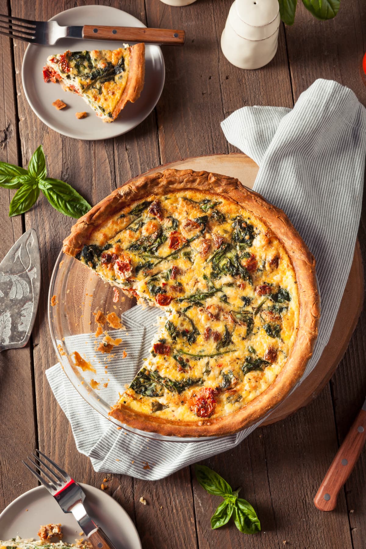 Pie dish of quiche with slice removed