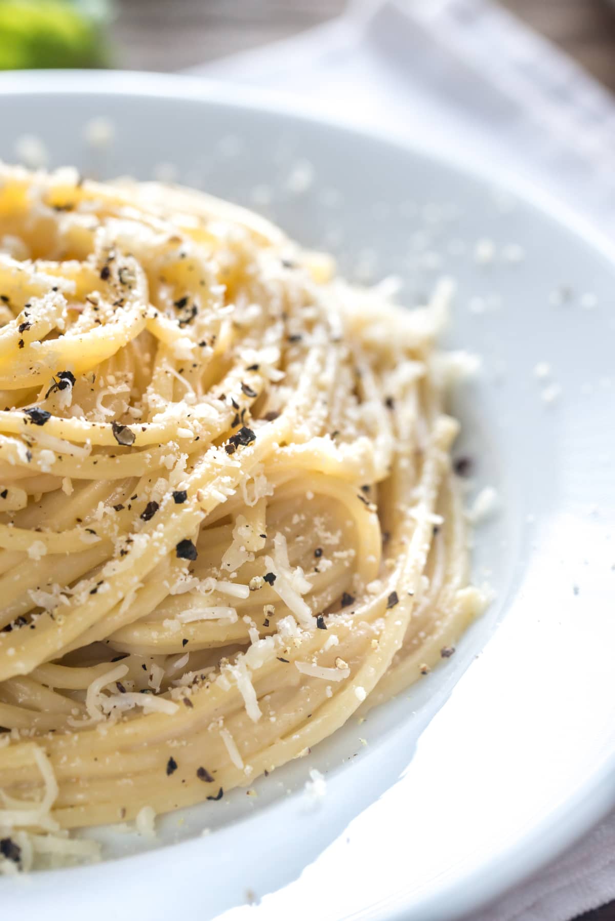 A plate of cacio e pepe pasta, close-up view, uniform background.  Famous dish of Roman cuisine.