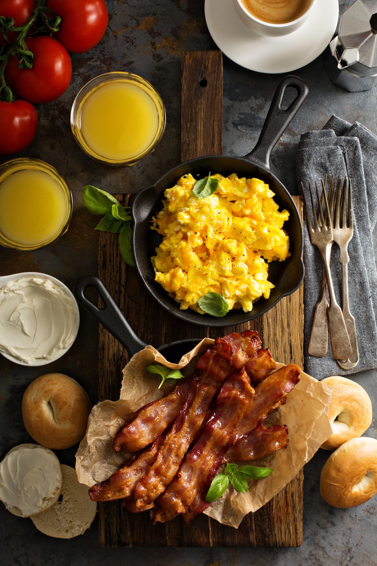 Big breakfast with bacon, bagels and scrambled eggs on the table overhead