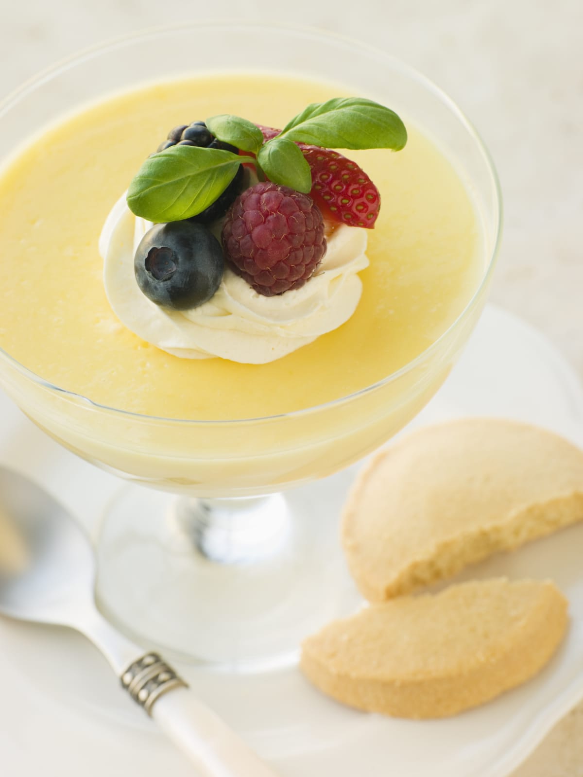 Lemon posset in a stemmed glass with berries