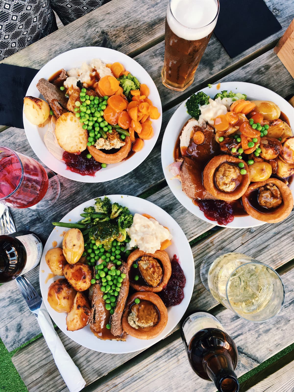 A plate of British Roast Dinner, with roast lamb, Yorkshire pudding, roast carrots, potatoes, broccoli and gravy, on a table in a pub in Highgate, London, UK