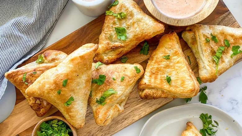 Samosas on serving tray with sauce on the side