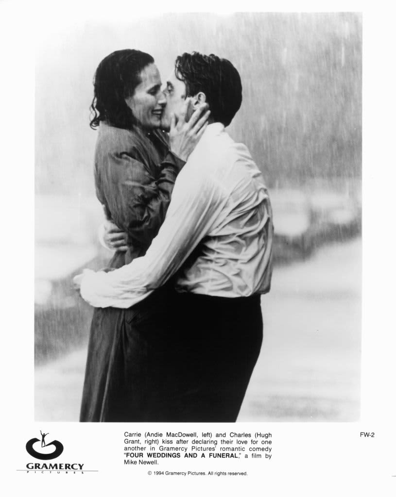 Andie MacDowell And Hugh Grant kiss in the rain in a scene from the film 'Four Weddings And A Funeral', 1994. (Photo by Gramercy Pictures/Getty Images)