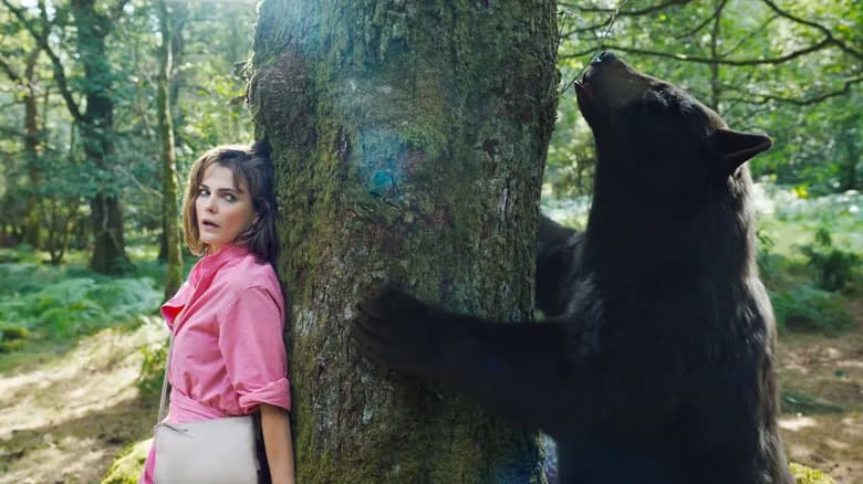 The bear in Cocaine Bear against a tree