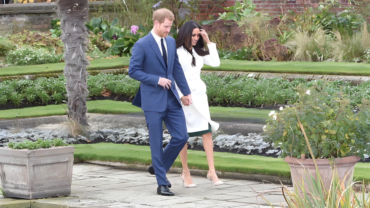 Prince Harry and Meghan Markle walking while holding hands.
