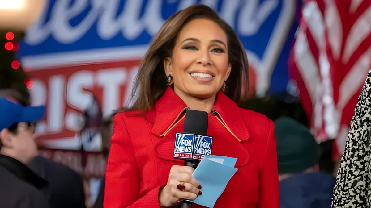 Jeanine Pirro smiling while holding a microphone.