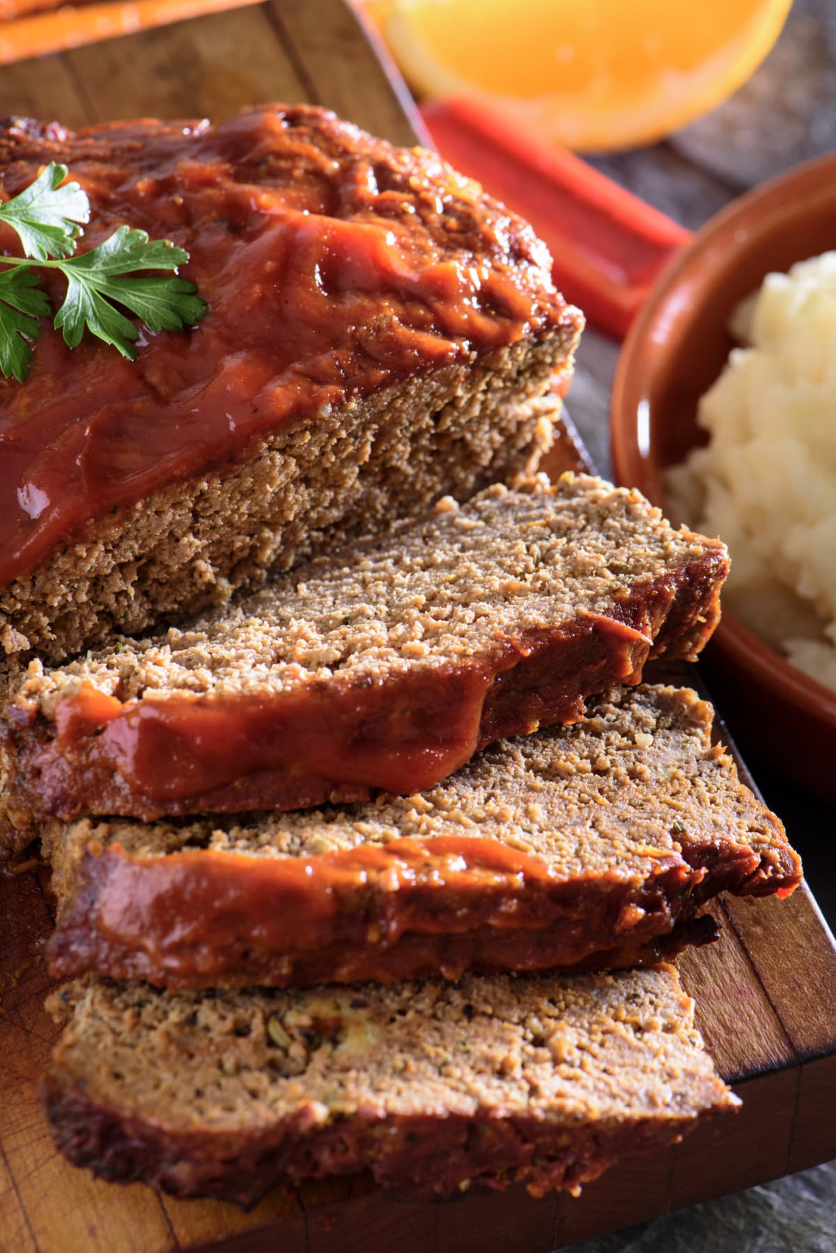 Sliced meatloaf topped with ketchup and fresh herb