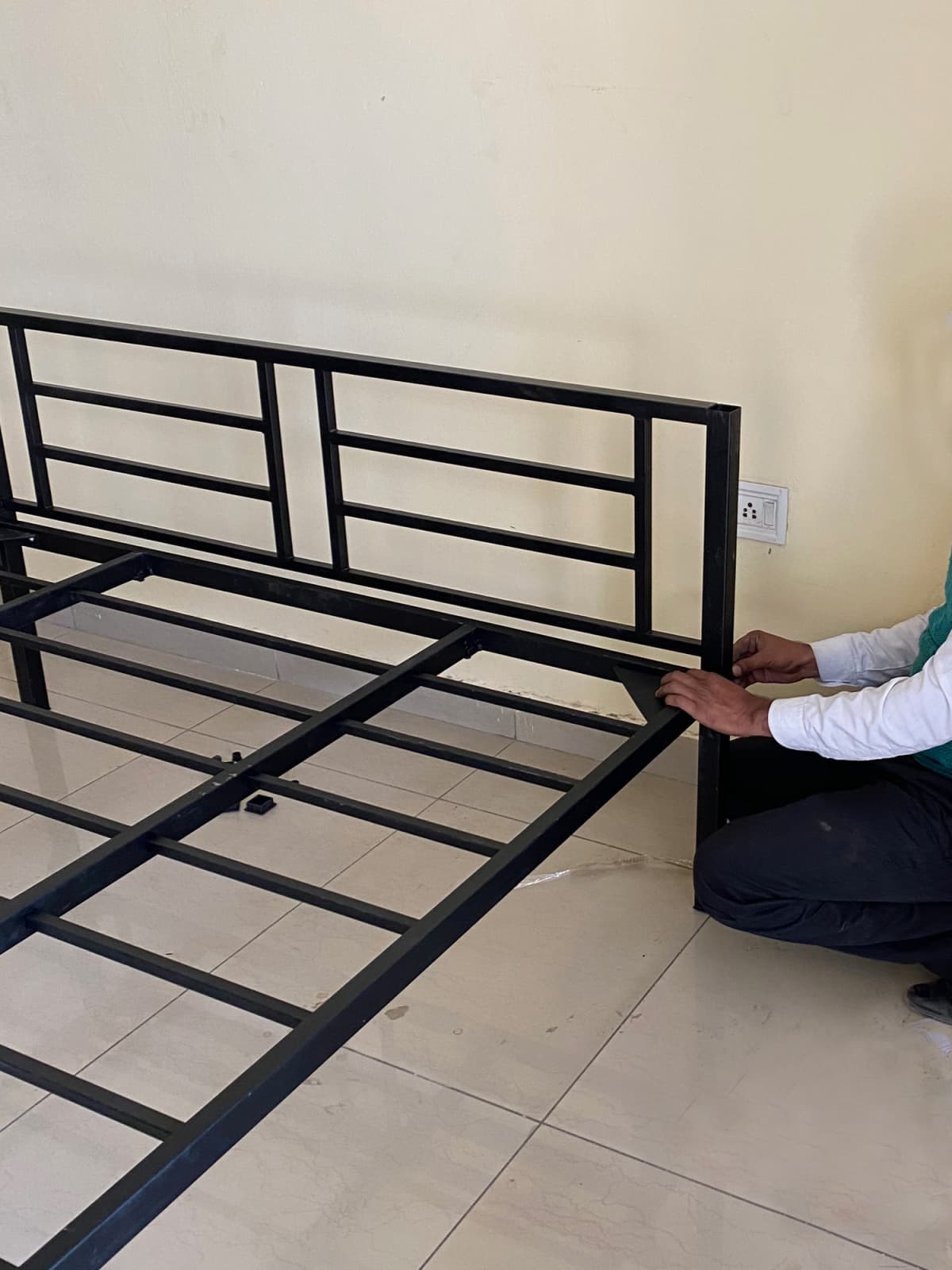 A handy man assembling a metal bed frame