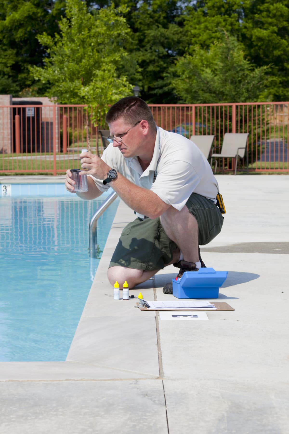 Man checking the chemicals in an in-ground pool