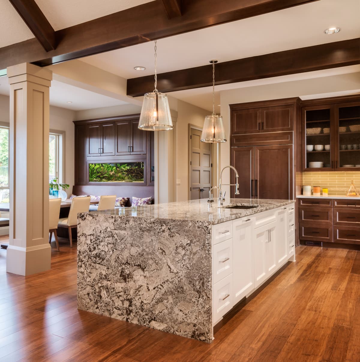 Kitchen with tall kitchen cabinet, countertop, island, and hardwood floor