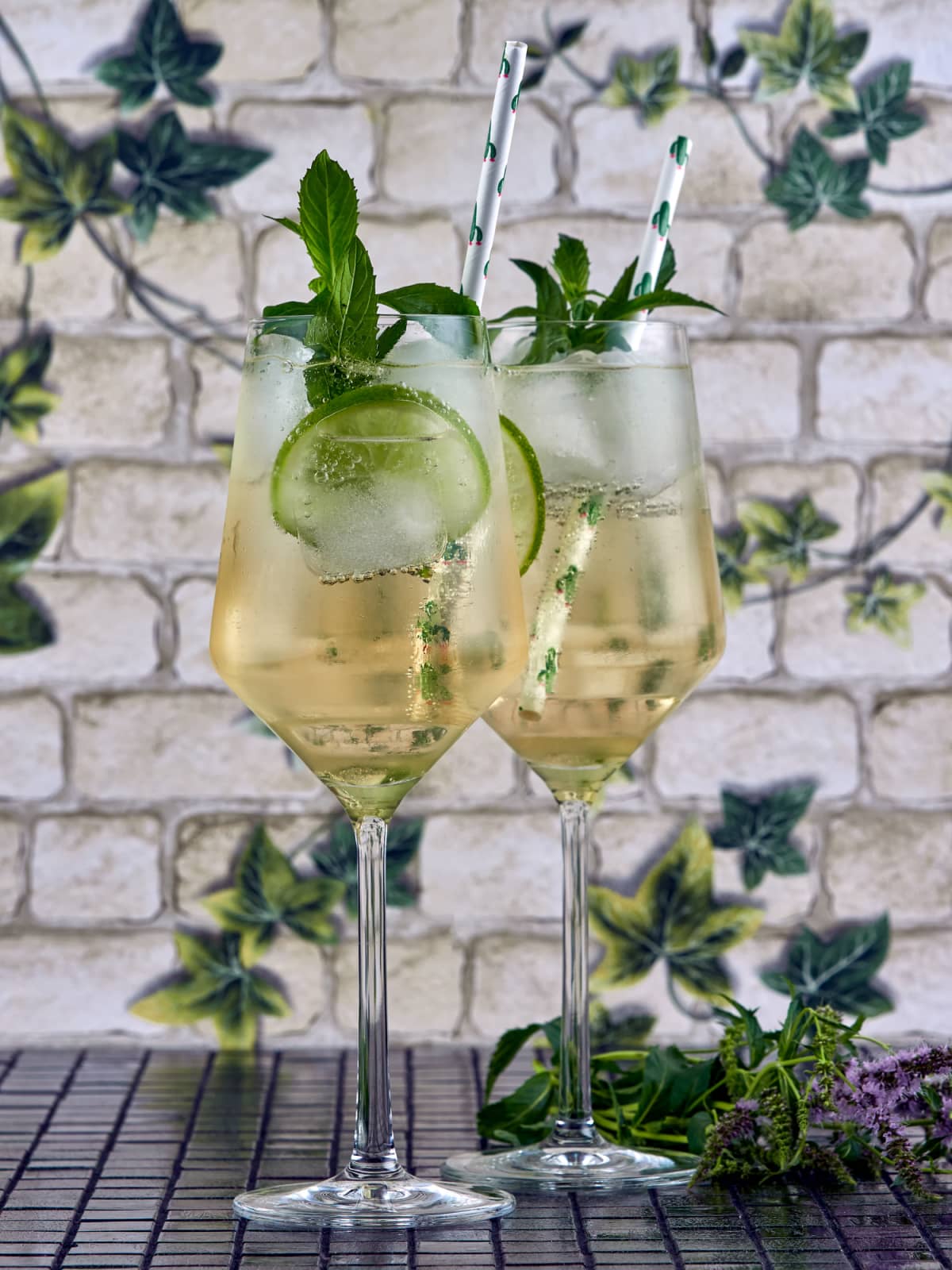 Two glasses of Hugo spritz with lime and mint garnishes