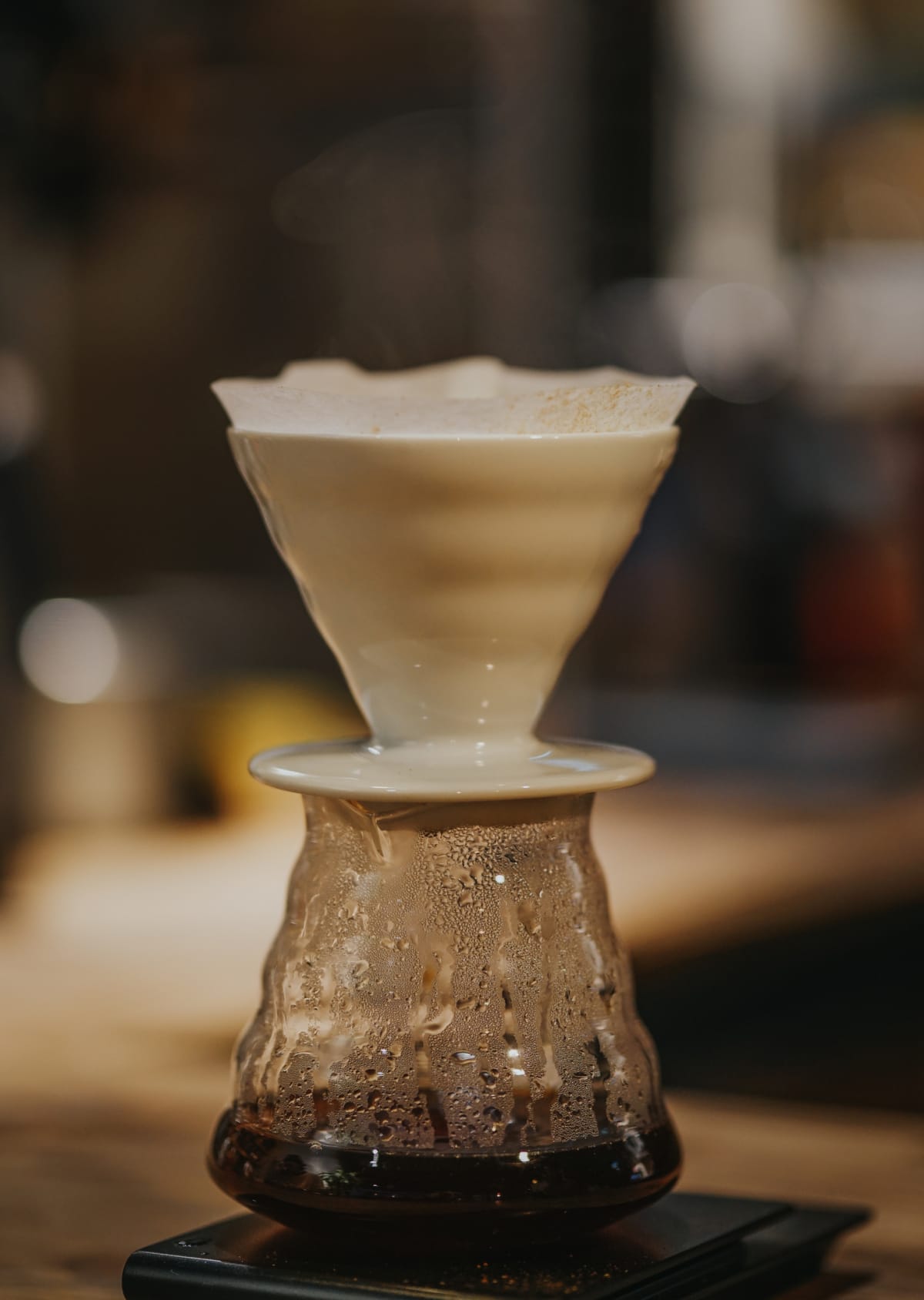 To make coffee with the Hario V60, pouring the measured coffee into the hopper